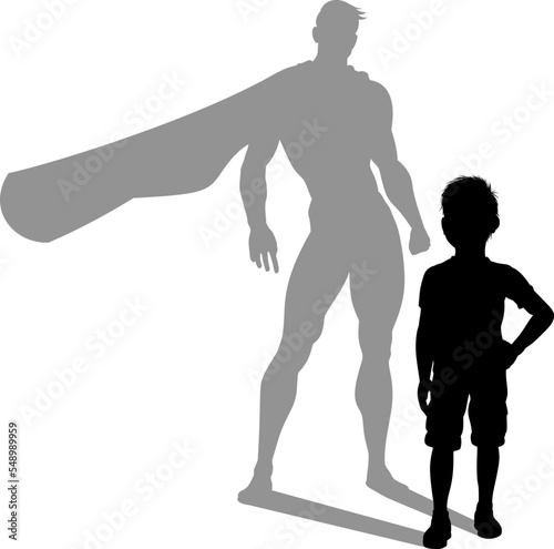 A superhero child or kid boy revealed by his shadow silhouette as a super hero in a cape.