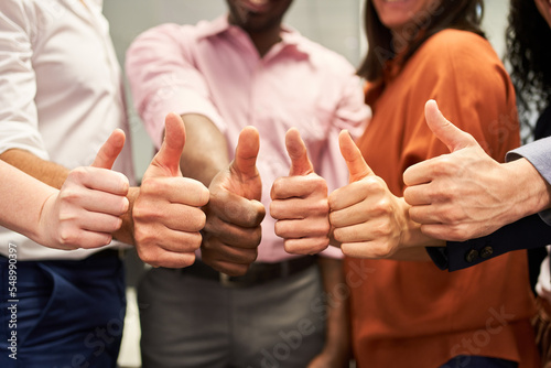 Group of business people showing thumbs up as a team