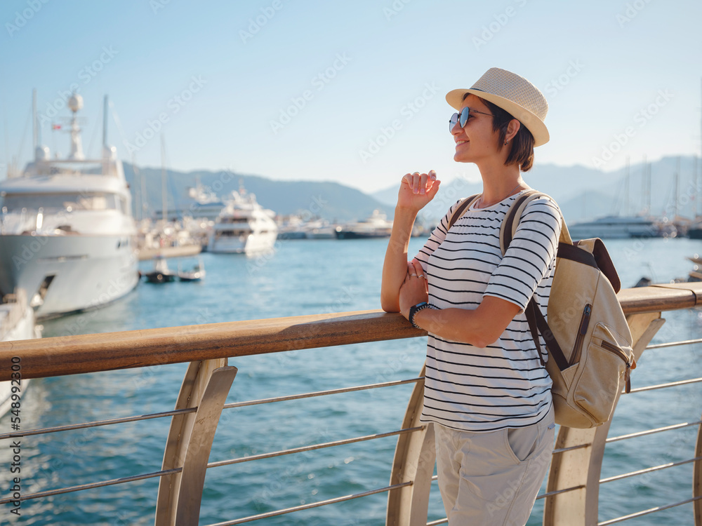 Fototapeta premium Marmaris is resort town on Turkish Riviera, also known as Turquoise Coast. Marmaris is great place for sailing and diving. Asian woman with hat walking on pier in harbor.