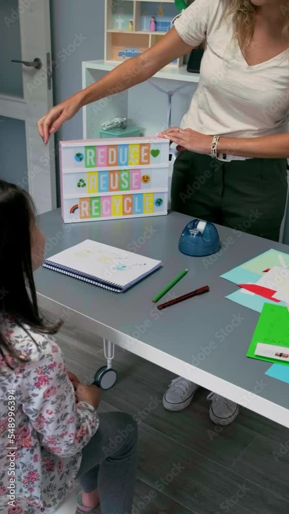 Unrecognizable female teacher using led lightbox with text reduce