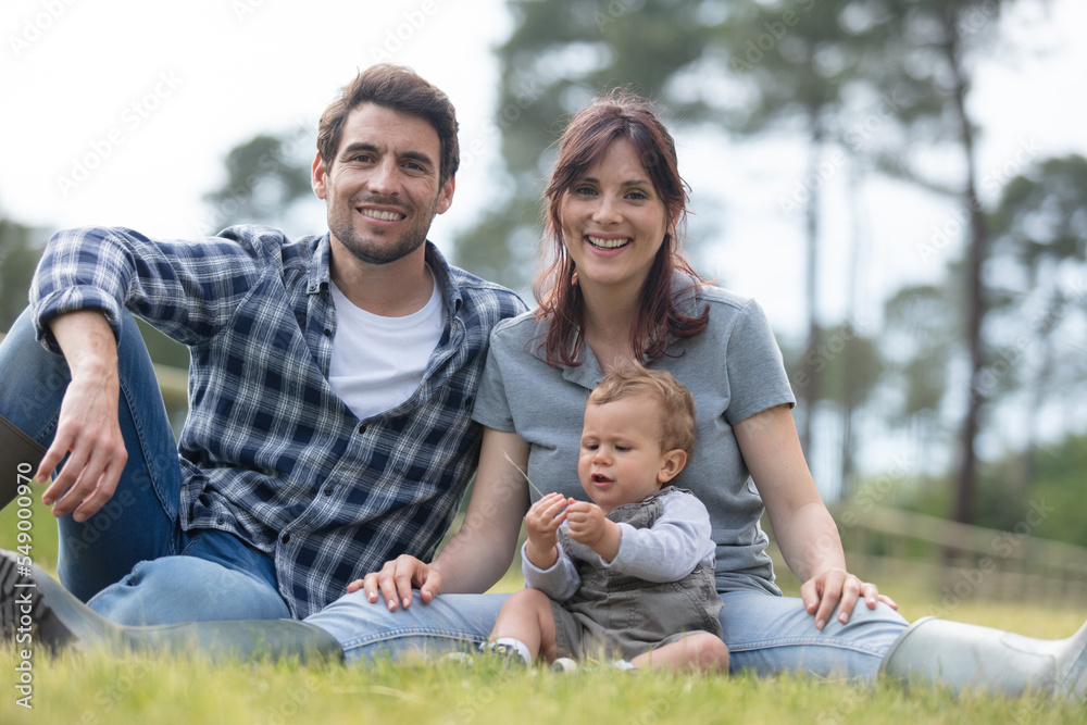 cheerful young family spending time together at the farm