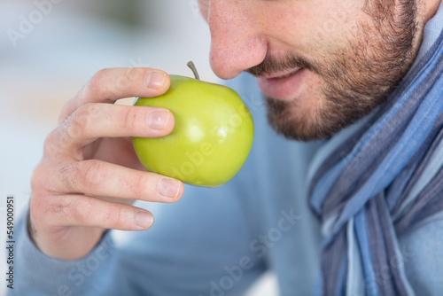 young man smelling an apple