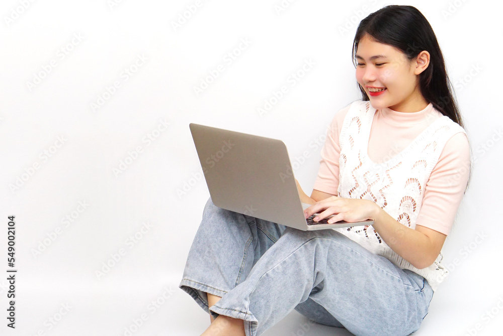 Young Asian cheerful woman sitting and using laptop. Technology and learning concept. Young Asian cheerful woman sitting and using laptop. Technology and learning concept.