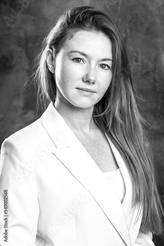 Portrait of a young red-haired woman in a dark studio