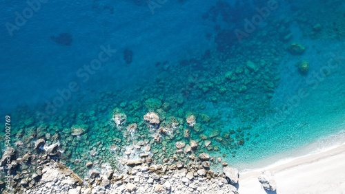 A bird s eye view of a deserted beach The white sandy coastline Submerged cliffs