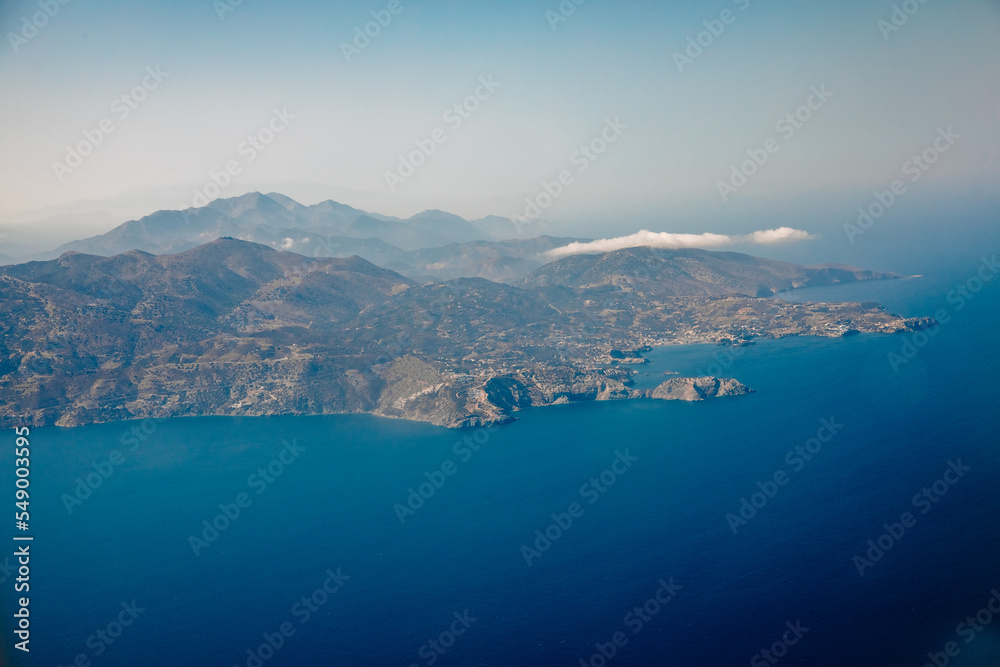Top view of an island in the Mediterranean Sea. Image from an airplane on a mediterranean island with blue water