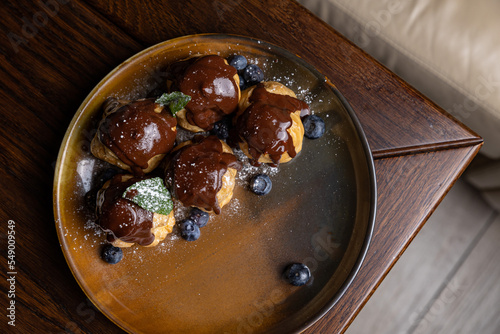 delicious profiteroles on a plate in a restaurant
