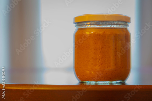 Selective focus of a pot of Pindakaas on wooden table, Peanut butter is a food paste or spread made from ground dry-roasted peanuts, It contains additional ingredients that modify the taste or texture photo