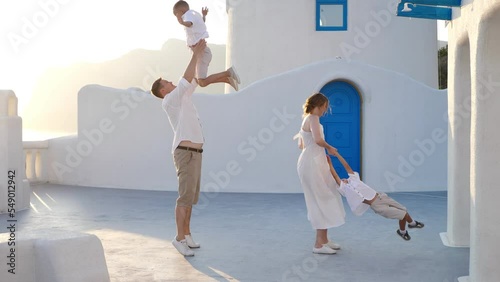 Happy family with children on vacation in Santorini, Greece. Parents have fun with their children.