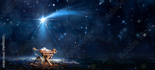Photographie Nativity Scene - Birth Of Jesus Christ With Manger In Snowy Night And Starry Sky