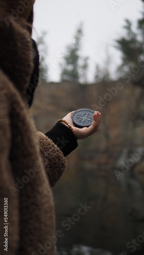 Fototapeta Naklejka Na Ścianę i Meble -  a man holds a compass near a river in the mountains