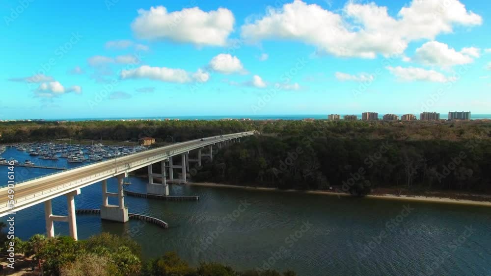 Aerial Shot Of Vehicles Moving On Bridge By Harbor In City, Drone Flying Forward Over Sea - Daytona Beach, Florida Aerial Shot Of Vehicles Moving On Bridge By Harbor In City, Drone Flying Forward Over Sea - Daytona Beach, Florida