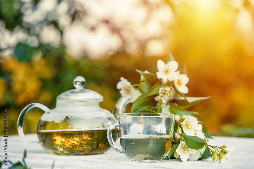 Philadelphus or garden jasmine flowers, healthy herbal tea cup of hot tea. Romantic dinner with therapeutic fragrant tea. Philadelphus or garden jasmine flowers, healthy herbal tea cup of hot tea. Romantic dinner with therapeutic fragrant tea.