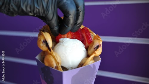 Chef decorates Hong Kong bubble waffle with ice cream berries. photo