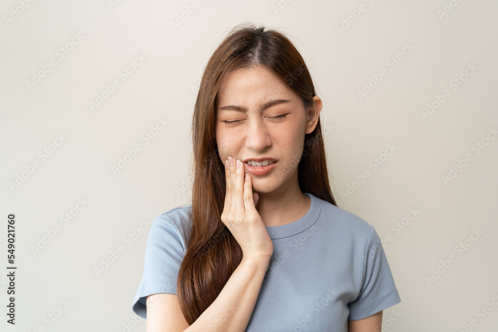 Face expression suffering from sensitive teeth, Asian young woman touching cheek Face expression suffering from sensitive teeth, Asian young woman touching cheek