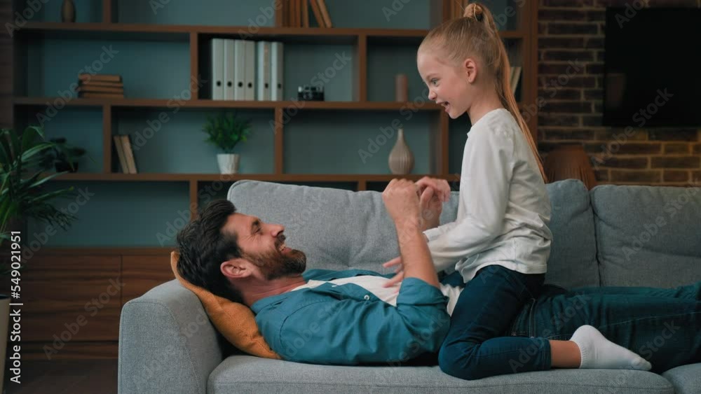Little playful cute girl young child kid playing with father on