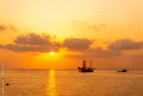 Silhouette, Offshore Jack Up Rig in The Middle of The Sea at Sunset Time © Jemang