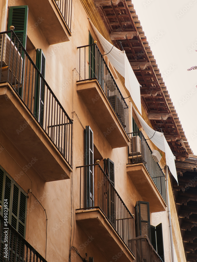 Partial view of a house facade, residential building, view of balconies and shutters, view from below Partial view of a house facade, residential building, view of balconies and shutters, view from below