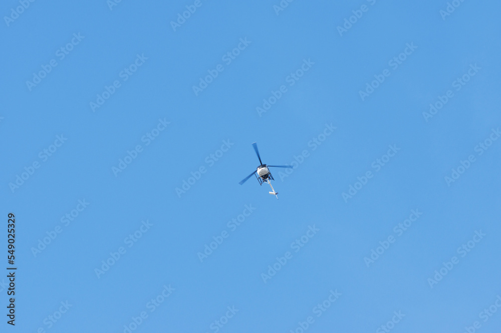 Helicopter flying high in the sky, Netherlands. With a clear blue skyaltitude Helicopter flying high in the sky, Netherlands. With a clear blue skyaltitude