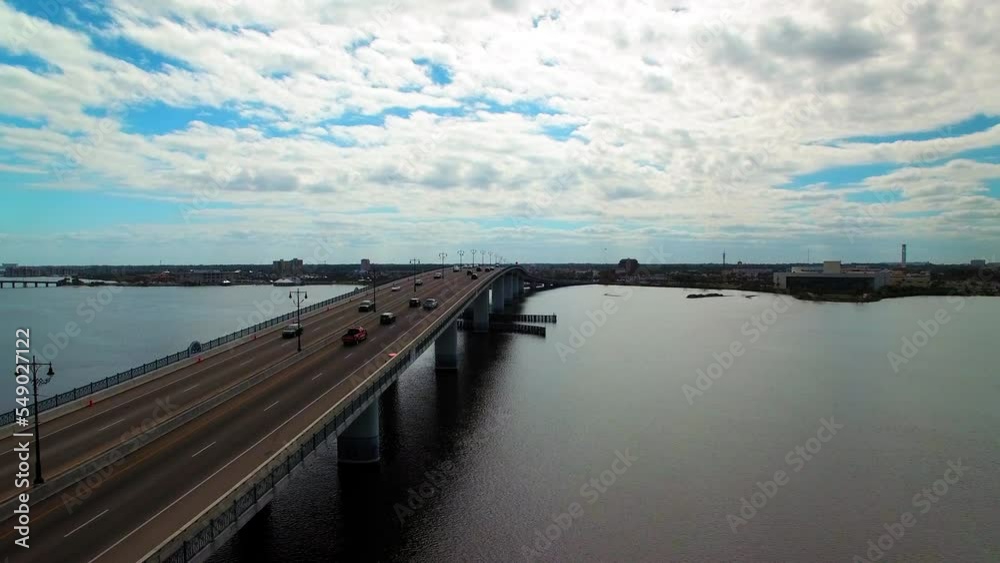 Aerial Lockdown Shot Of Cars Moving On Bridge Road Amidst Clouds And Sea - Daytona Beach, Florida Aerial Lockdown Shot Of Cars Moving On Bridge Road Amidst Clouds And Sea - Daytona Beach, Florida