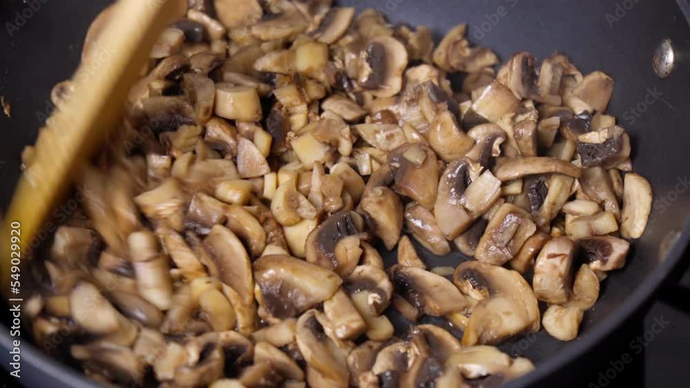 Fried mushrooms and eggs in a pan. The process of cooking breakfast. Close up. Selective focus Fried mushrooms and eggs in a pan. The process of cooking breakfast. Close up. Selective focus