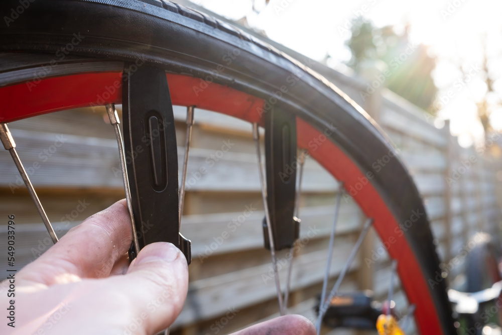 Cyclists hand removes the tire with a special lever tool. Repairing a