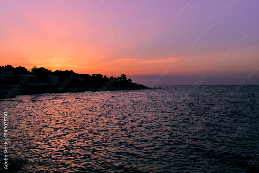 Beach coastline silhouette sunset violet orange colors idilic summer vacation denia