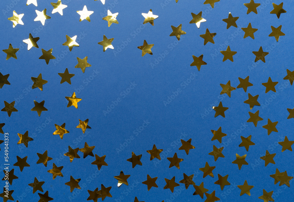 Golden confetti stars on color background, top view Golden confetti stars on color background, top view