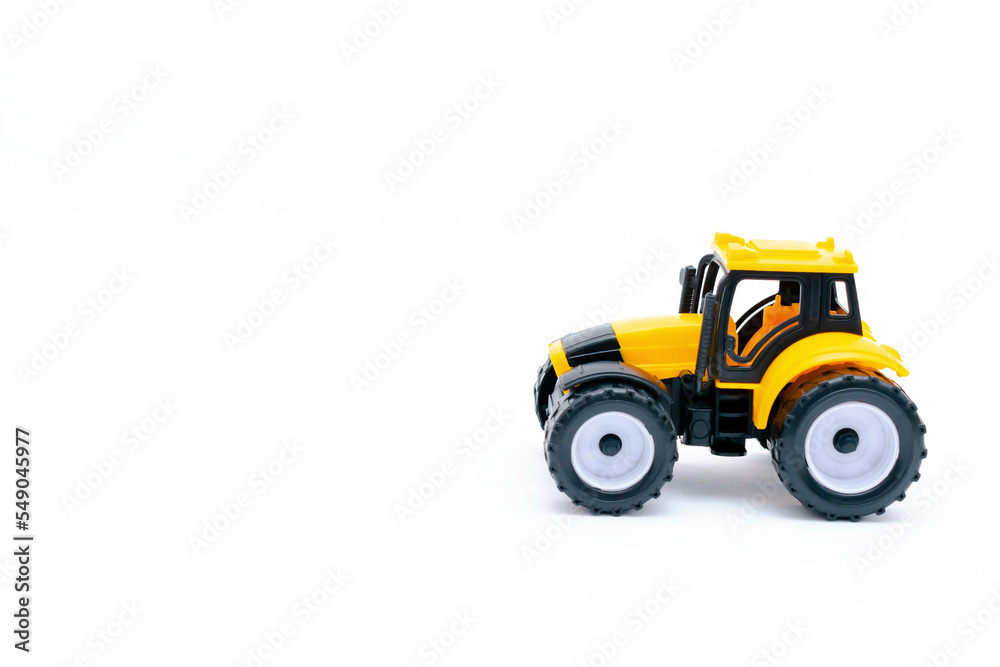 Fototapeta premium yellow plastic tractor, truck, lorry, car toy isolated, toys for children, kids development, playing