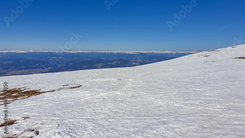 Scenic view of snow covered alpine meadows and Koralpe mountains seen from Ladinger Spitz, Saualpe, Lavanttal Alps, Carinthia, Austria, Europe. Untouched field of snow. Ski touring snowshoeing tourism