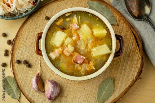 Sauerkraut soup with potatoes, carrots and bacon. Soup with cabbage