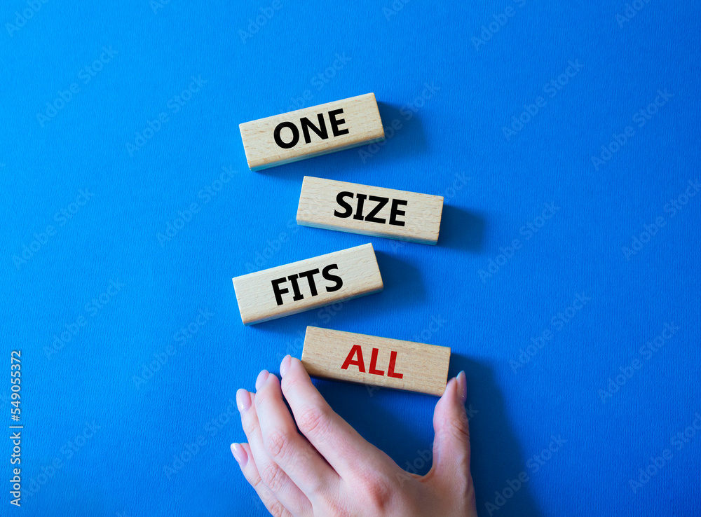 One size fits all symbol. Concept words One size fits all on wooden blocks. Beautiful blue background. Businessman hand. Business and One size fits all concept. Copy space. One size fits all symbol. Concept words One size fits all on wooden blocks. Beautiful blue background. Businessman hand. Business and One size fits all concept. Copy space.