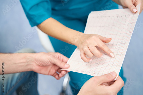 Foto Nurse pointing finger at location on heart rate chart on printout