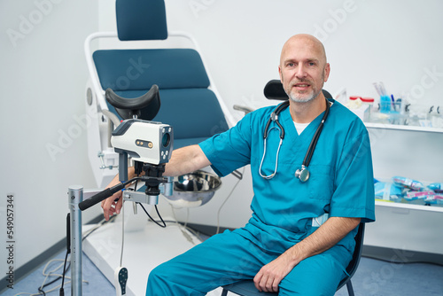 Doctor is sitting next to the gynecological examination chair