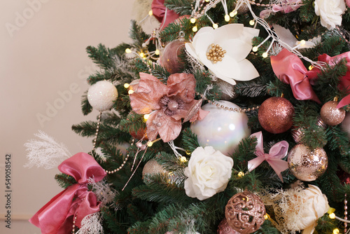 Christmas, New Year interior with pink and white fur-tree, fir tree decoration with balls and flowers photo