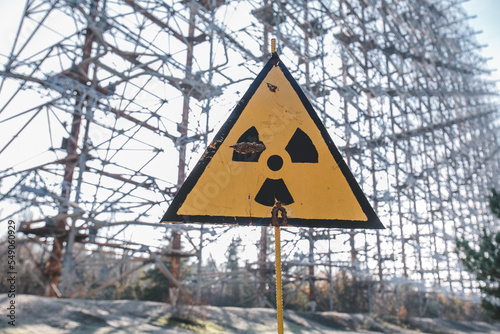 Yellow sign of radiation hazard against the background of the military building "Duga", Chernobyl region, exclusion zone