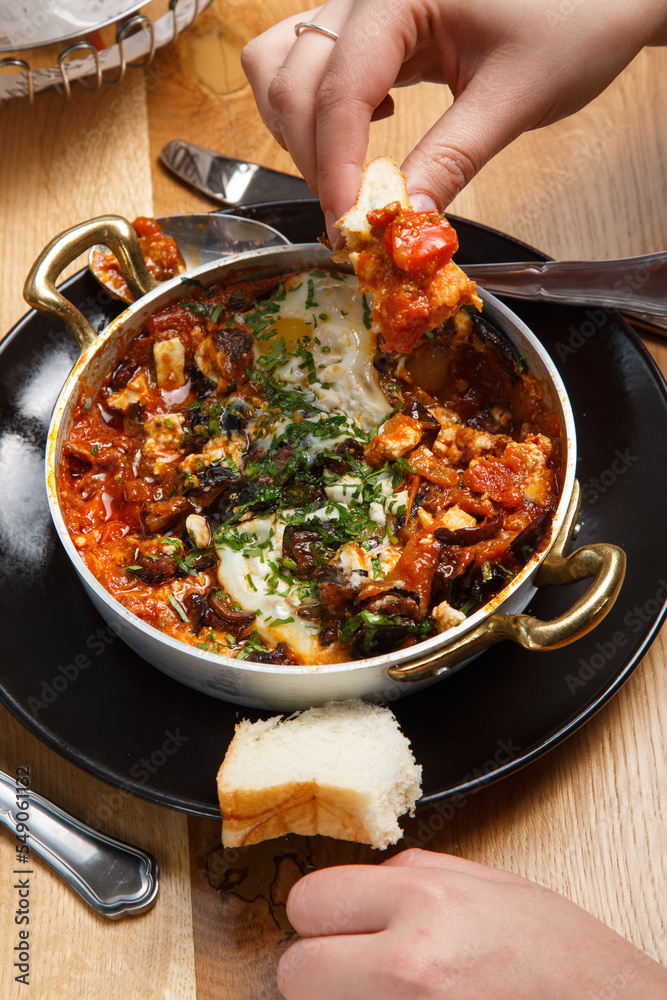 Shakshuka with bread in a pan. close up eating Shakshuka with bread in a pan. close up eating