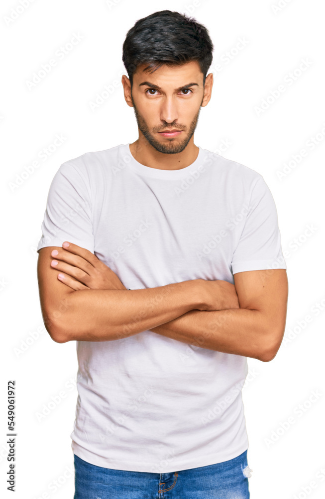 Obraz premium Young handsome man wearing casual white tshirt skeptic and nervous, disapproving expression on face with crossed arms. negative person.
