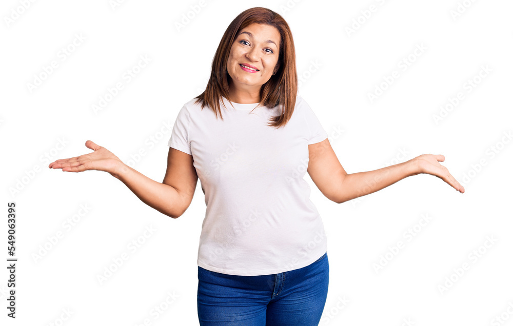 Middle age latin woman wearing casual white tshirt smiling showing both hands open palms, presenting and advertising comparison and balance Middle age latin woman wearing casual white tshirt smiling showing both hands open palms, presenting and advertising comparison and balance