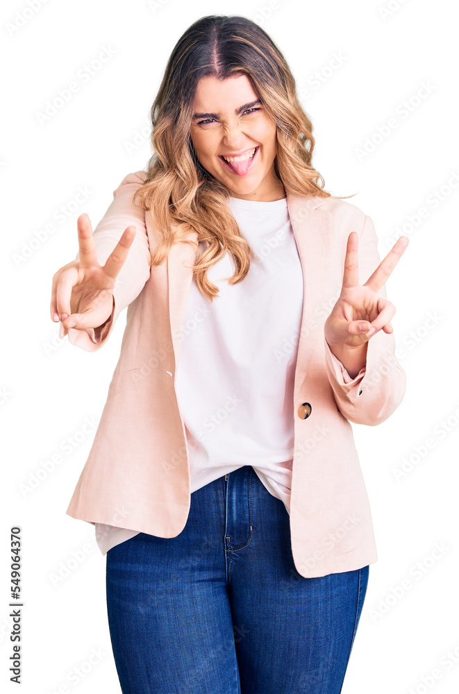 Young caucasian woman wearing business clothes smiling with tongue out showing fingers of both hands doing victory sign. number two. Young caucasian woman wearing business clothes smiling with tongue out showing fingers of both hands doing victory sign. number two.