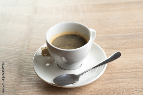 A cup of coffee on a saucer isolated on light background. Double Americano