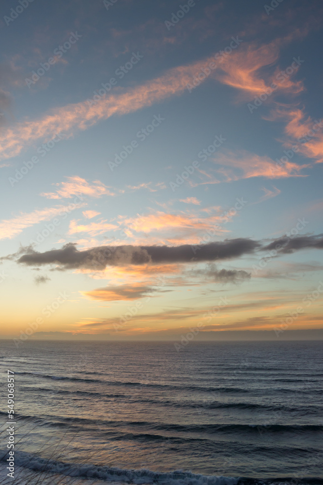 Pink and golden clouds in blue sky, sunset over the sea. Bajamar, Tenerife, Canary Islands.  