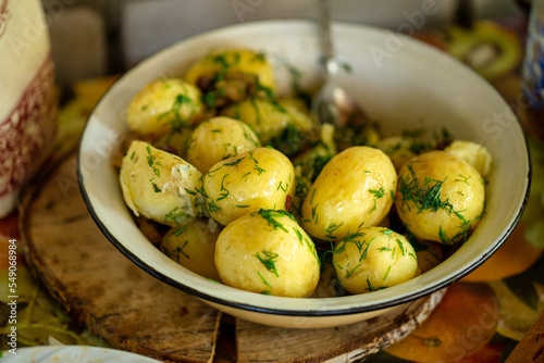 Fresh boiled new potatoes with fresh dill on rustic background