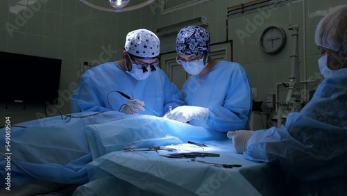 Quadro su tela Medical team performing a surgical operation in a modern operating room