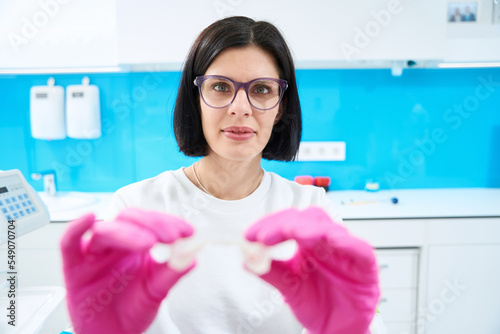 Free Download Orthodontist holds a transparent cap in her hands - GFXLoad