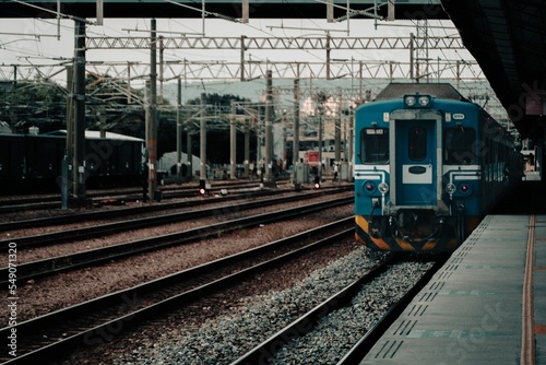 Obraz na plátně Departing train on railways in an empty station