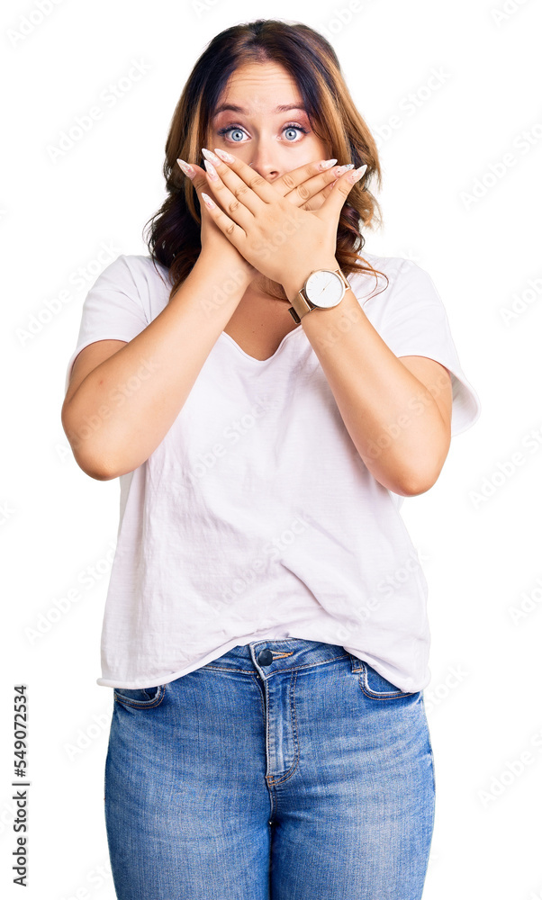 Young beautiful caucasian woman wearing casual white tshirt shocked covering mouth with hands for mistake. secret concept. Young beautiful caucasian woman wearing casual white tshirt shocked covering mouth with hands for mistake. secret concept.