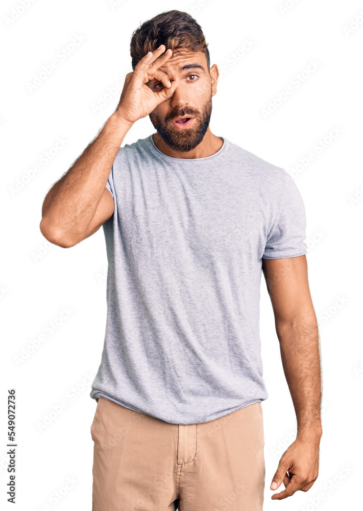 Young hispanic man wearing casual clothes doing ok gesture shocked with surprised face, eye looking through fingers. unbelieving expression. Young hispanic man wearing casual clothes doing ok gesture shocked with surprised face, eye looking through fingers. unbelieving expression.