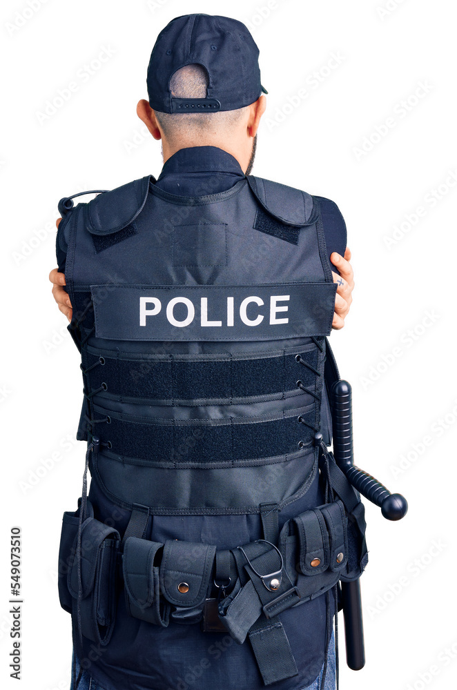 Young handsome man wearing police uniform hugging oneself happy and positive from backwards. self love and self care Young handsome man wearing police uniform hugging oneself happy and positive from backwards. self love and self care
