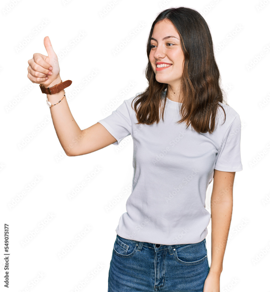 Young beautiful woman wearing casual white t shirt looking proud, smiling doing thumbs up gesture to the side